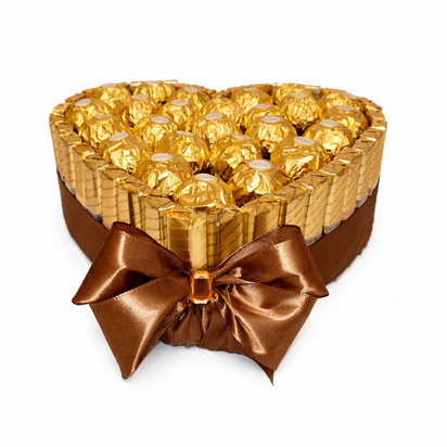 Hartvormige luxe chocoladetaart met gouden Ferrero Rocher en Merci chocoladerepen rondom. Afgewerkt met een elegante brede sati