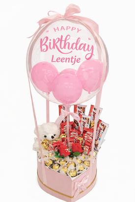 Handgemaakte luxe snoeptaart met een grote transparante ballon bedrukt met &ldquo;Happy Birthday&rdquo; en een gepersonalisee